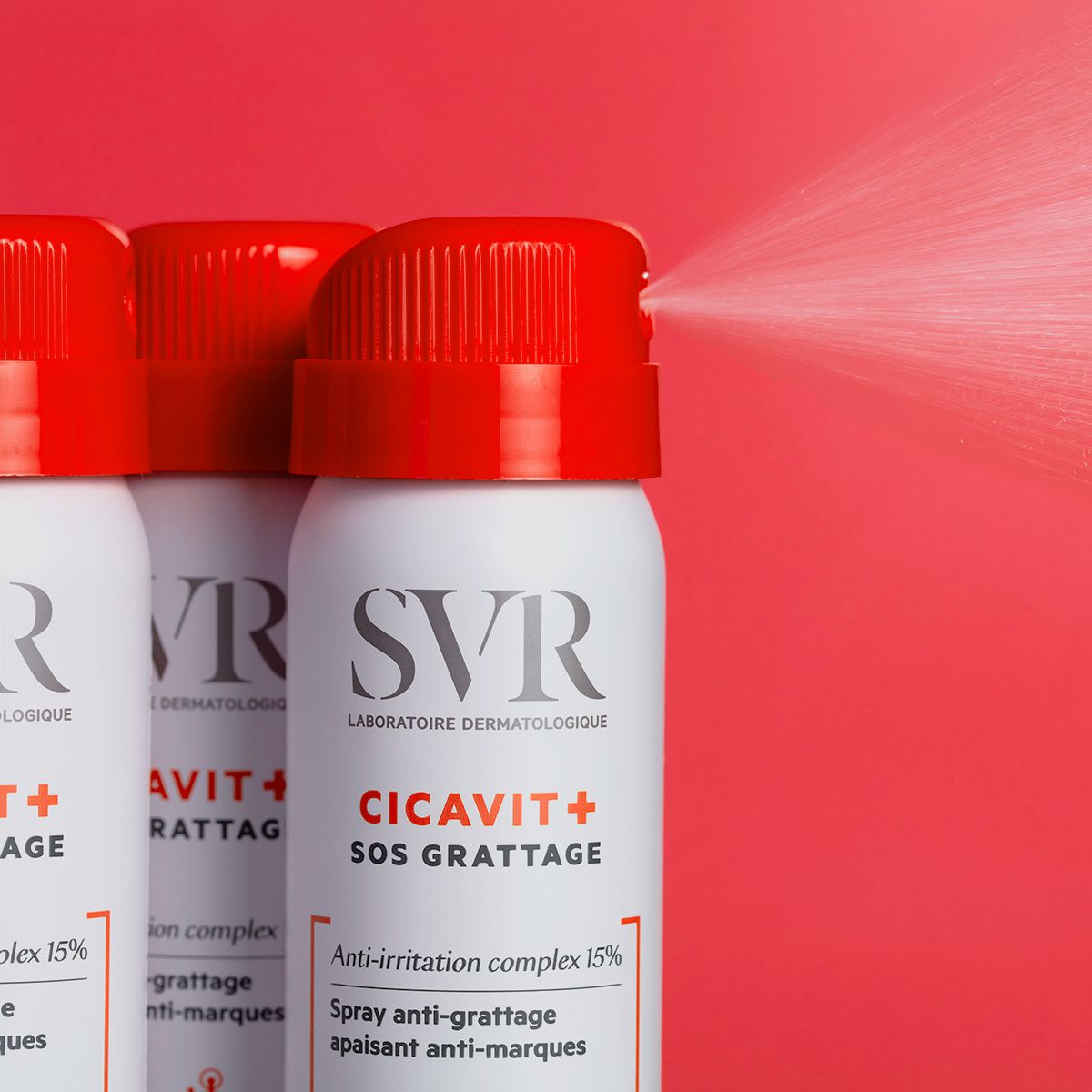 Spray anti-démangeaisons SVR Cicavit+ SOS Grattage en flacon blanc avec bouchon rouge diffusant une brume sur fond rouge.