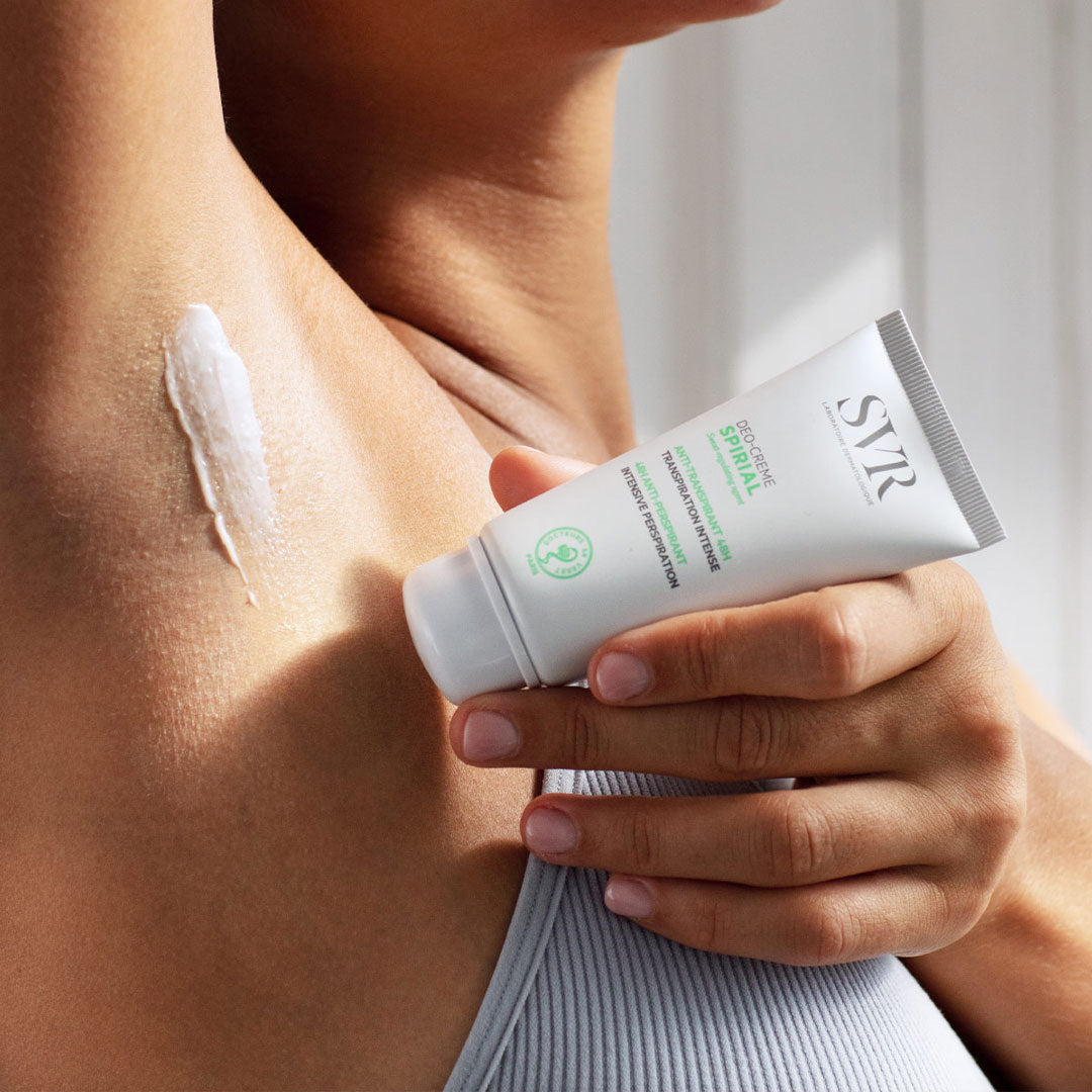 Tube de crème anti-transpirante SVR Spirial blanc appliqué sur une aisselle pour une efficacité 48h.