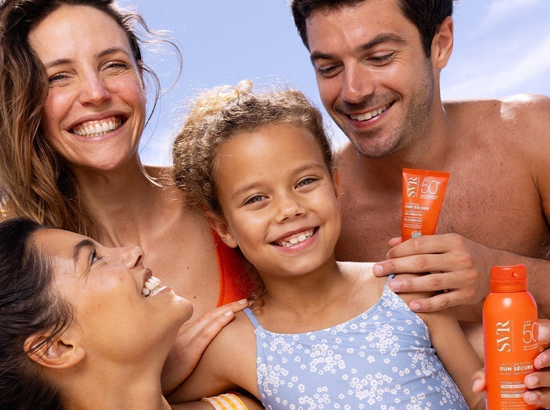 Famille souriante sous le soleil utilisant des crèmes solaires SVR SPF 50 pour protéger leur peau.