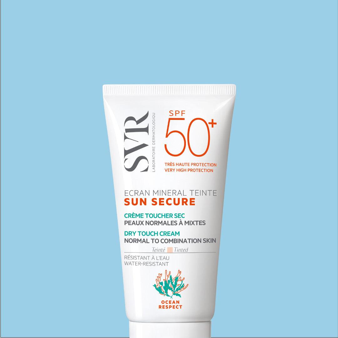 Tube blanc de crème solaire teintée SVR Sun Secure SPF50+ pour peaux normales à mixtes sur fond bleu clair.