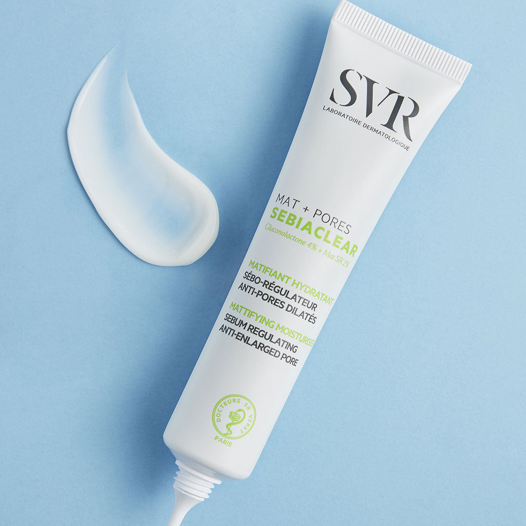 Tube de soin SVR Sebiaclear Mat+Pores blanc avec une texture crème fluide sur fond bleu clair.