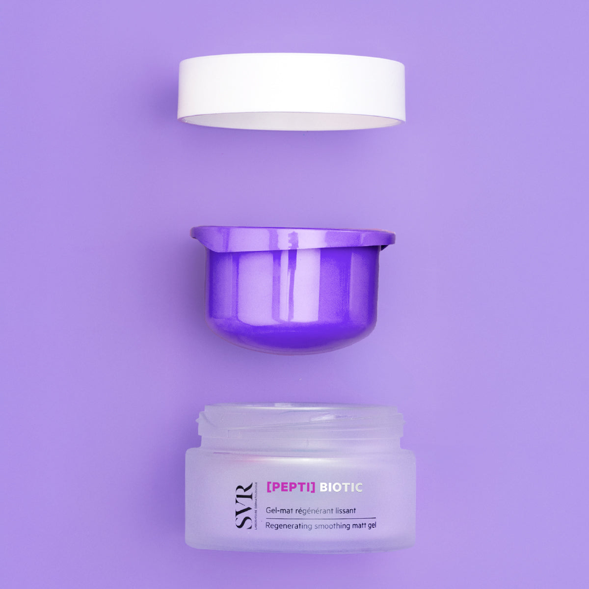 Pot de soin SVR [PEPTI]BIOTIC ouvert avec couvercle blanc et contenant violet sur fond violet uni.