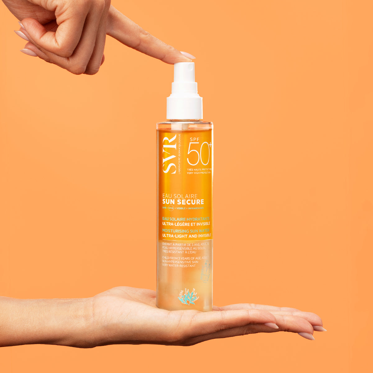 Flacon spray SVR SUN SECURE Eau Solaire SPF50+ transparent sur fond orange, tenu entre deux mains.